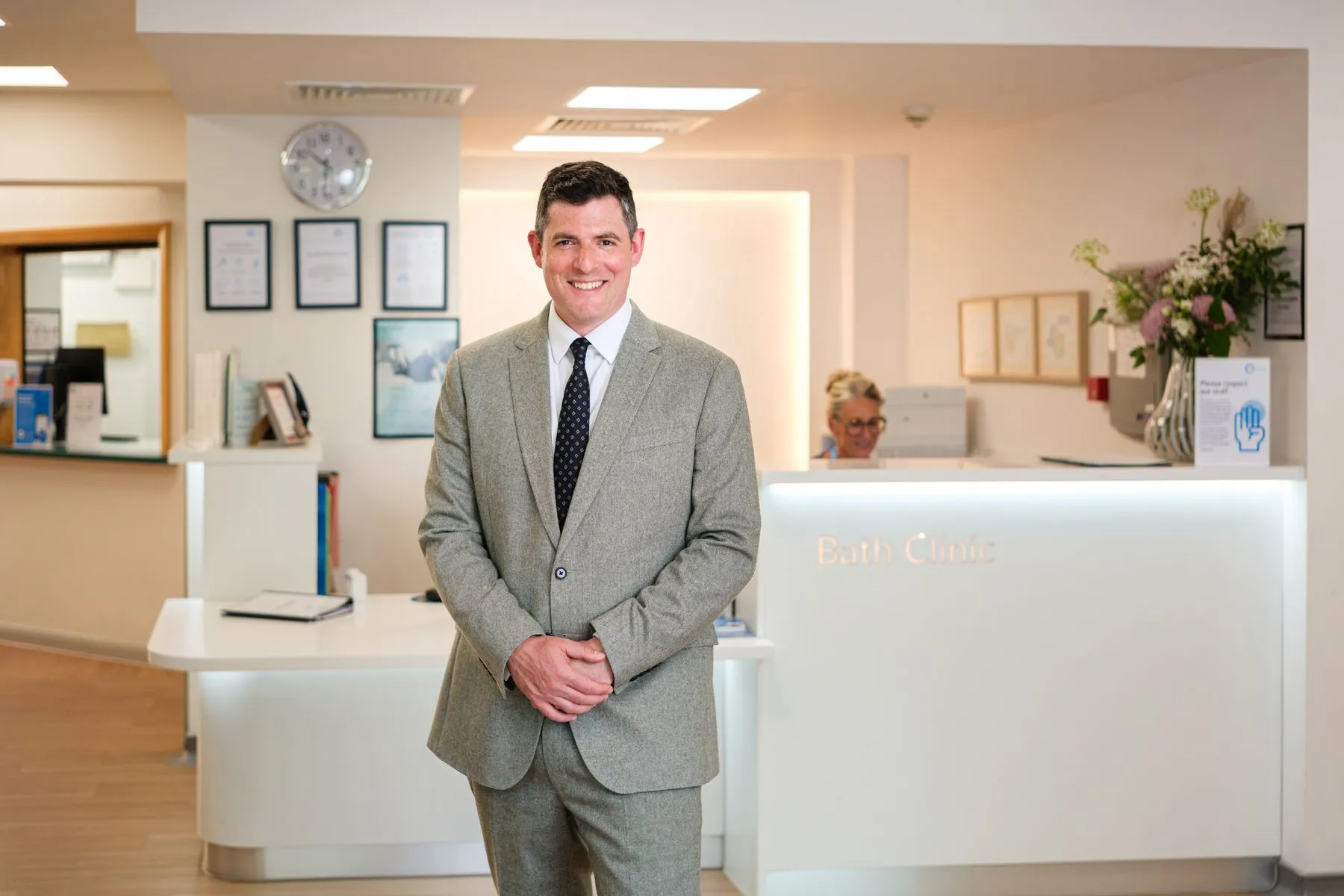 Mr James Berwin standing in the reception of The Bath Clinic, smiling.